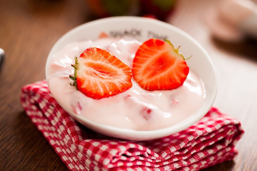 Imagem mostra receita de iogurte natural caseiro com morango