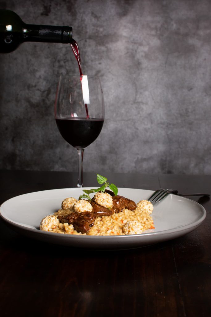 Imagem de arroz piamontese acompanhado de um bom vinho.