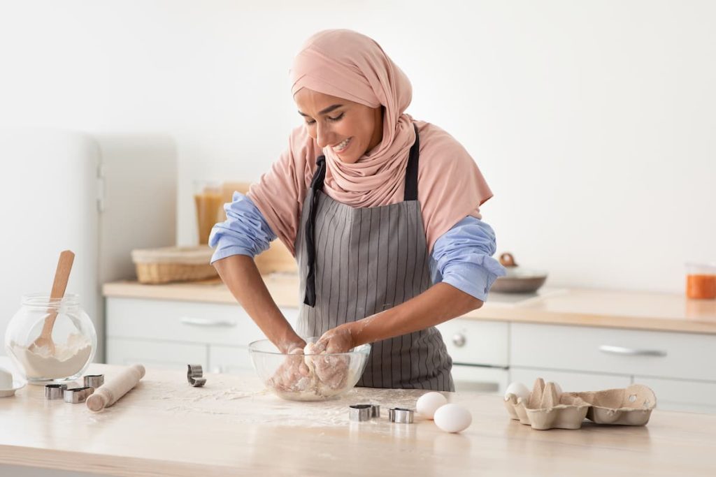 Imagem mostra mulher feliz preparando o biscoito de polvilho.