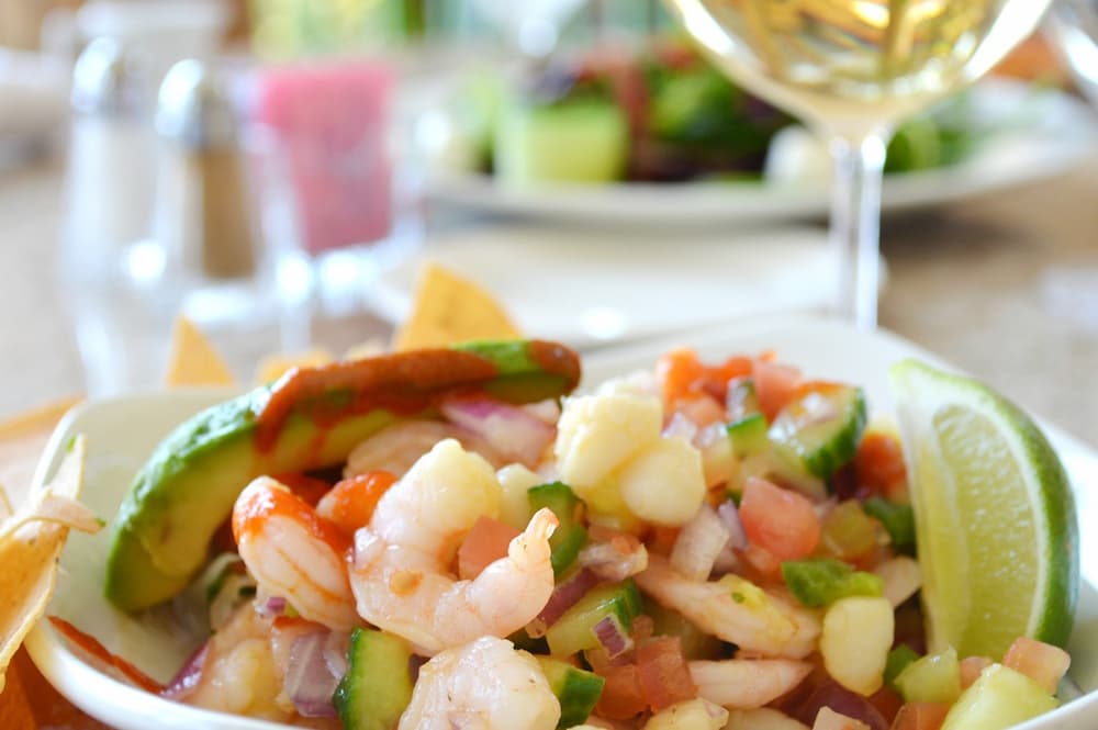 Imagem mostra ceviche prato muito servido em um dos melhores restaurantes chilenos, acompanhado de um bom vinho branco.