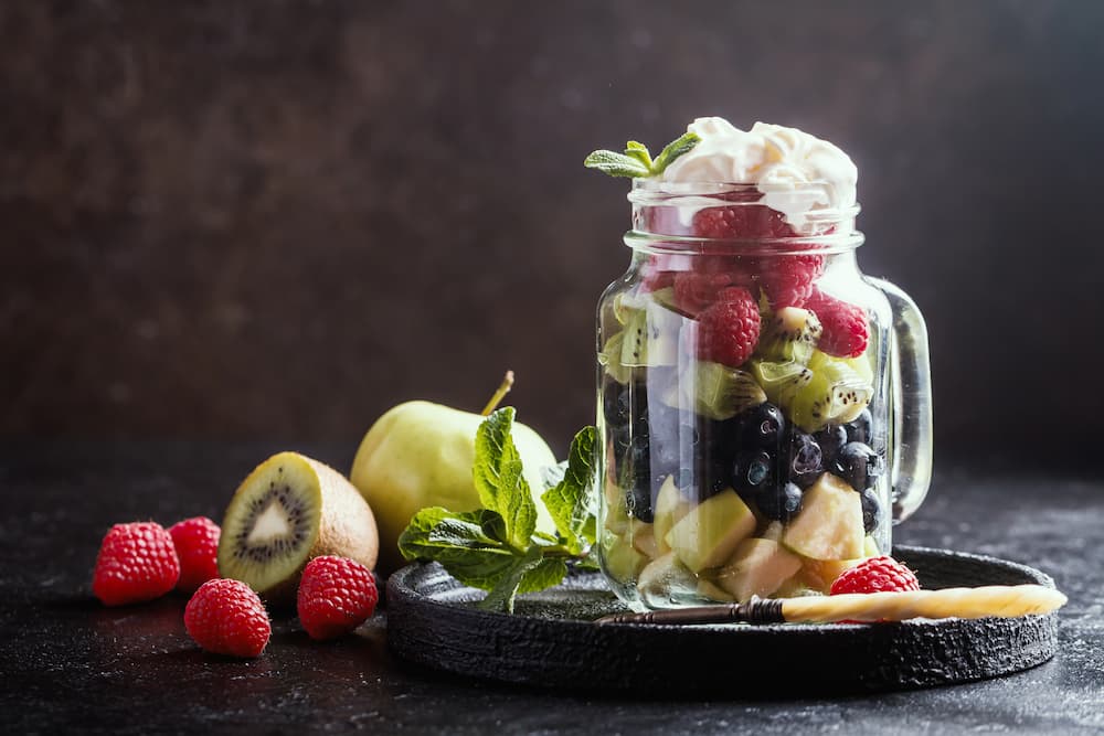 Imagem mostra salada de fruta armazenada em pote.