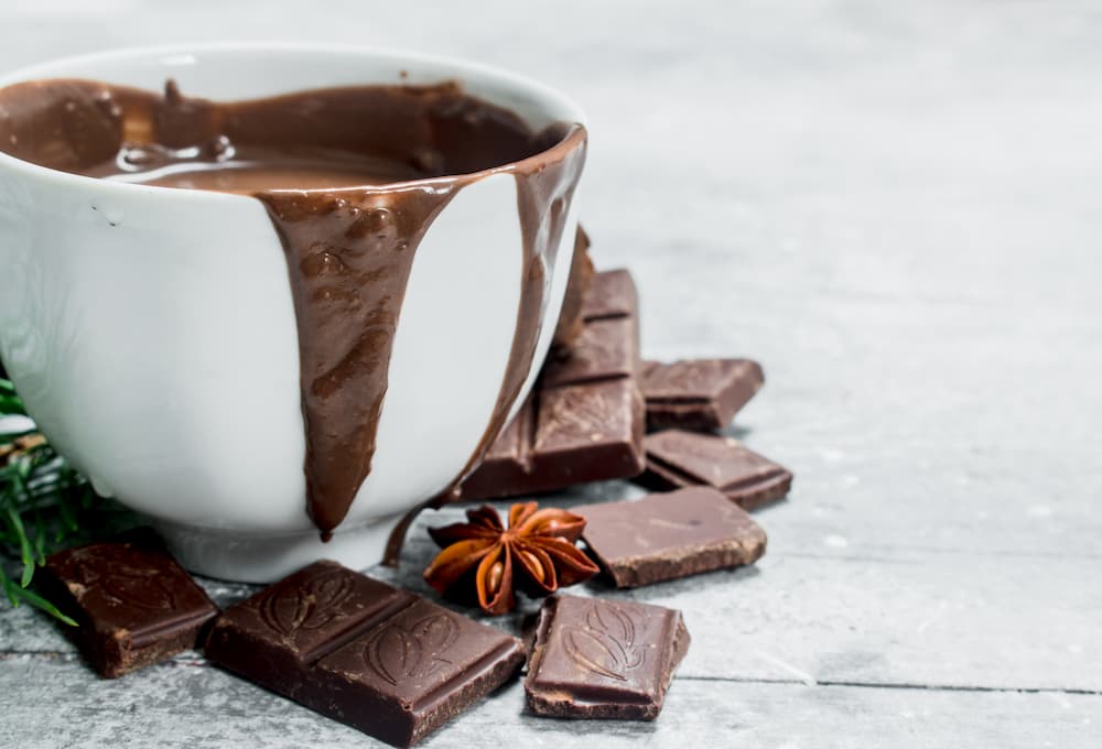 Imagem mostra xícara de chocolate quente com creme de leite, surpreendente e irresistível.