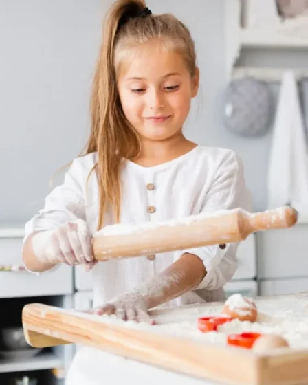 Imagem mostra uma menina usando um rolo na cozinha