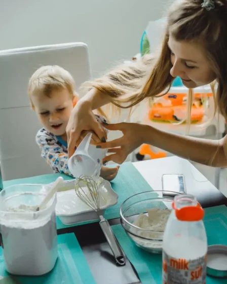 Imagem mostra mãe ajudando o filho a cozinhar