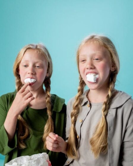 Imagem mostra duas meninas com marshmallow na boca