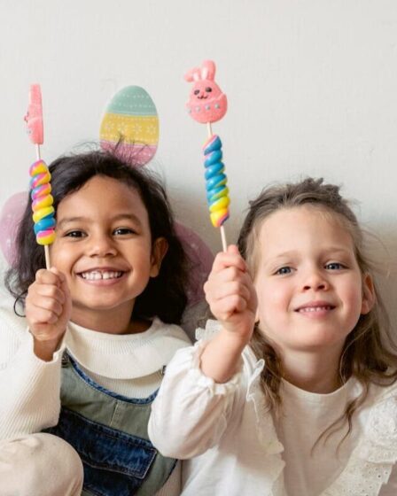 Imagem mostra duas crianças com doces nas mãos