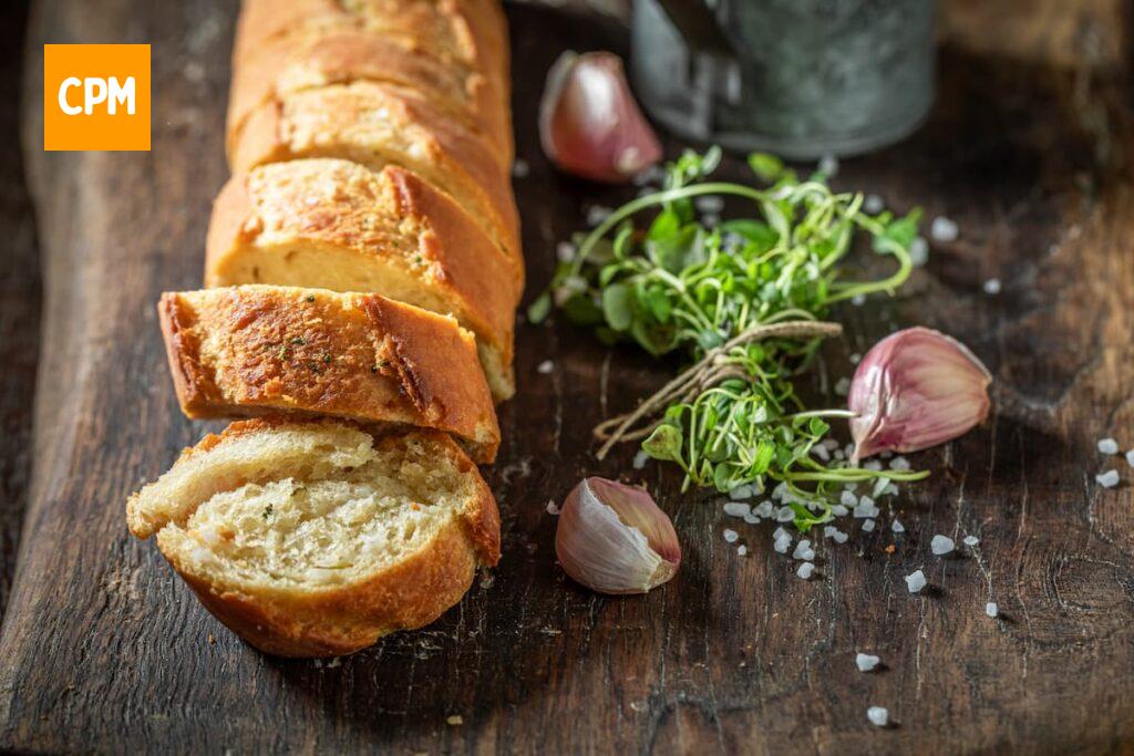 Imagem mostra baguete cortada e ideal para fazer pão de alho na airfryer.