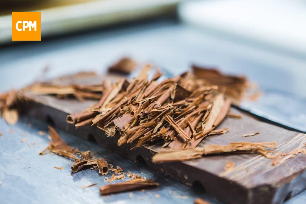 Imagem mostra raspas de chocolate usadas para fazer pipoca doce caramelizada.