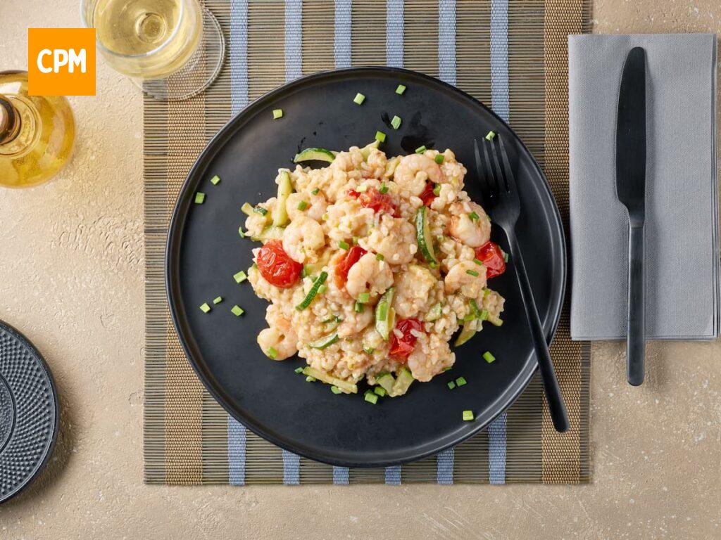 Imagem mostra um sofisticado prato de risoto de camarão com tomate e ervas.