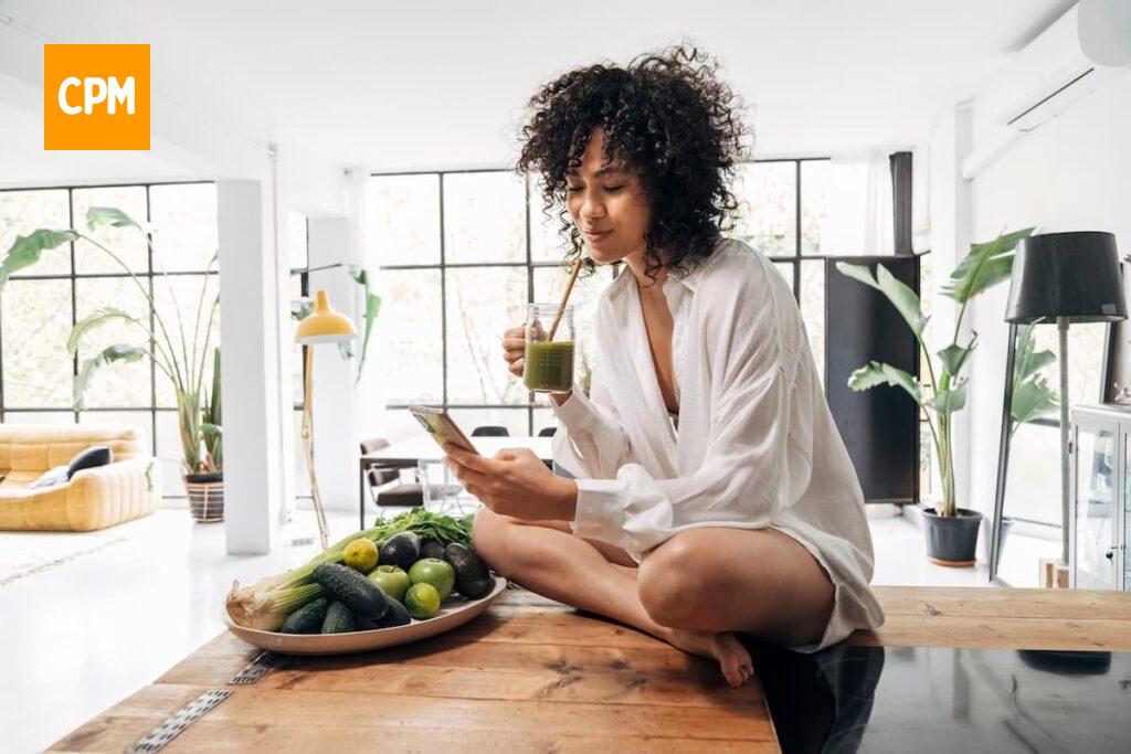 Imagem mostra jovem mulher consumindo o seu suco verde detox.