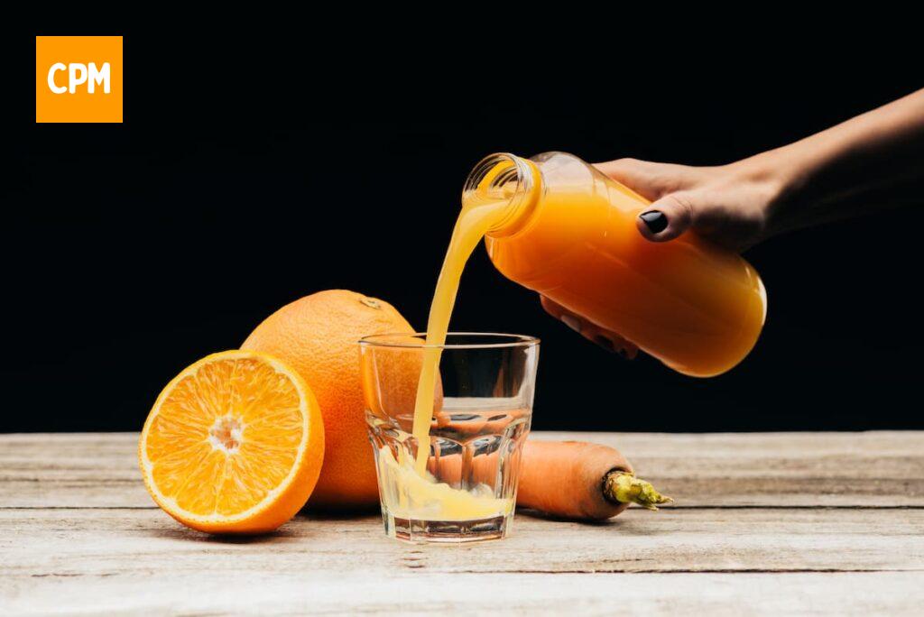 Imagem mostra suco de laranja com couve e gengibre.