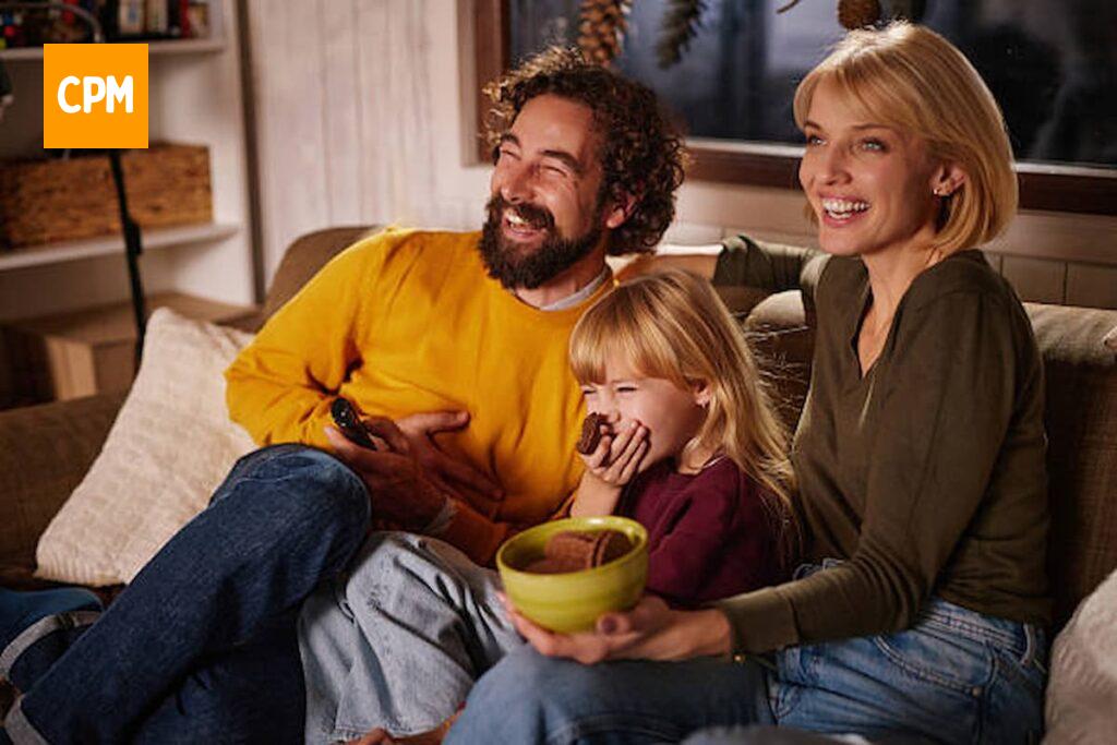 Imagem mostra família feliz assistindo jogo na TV.