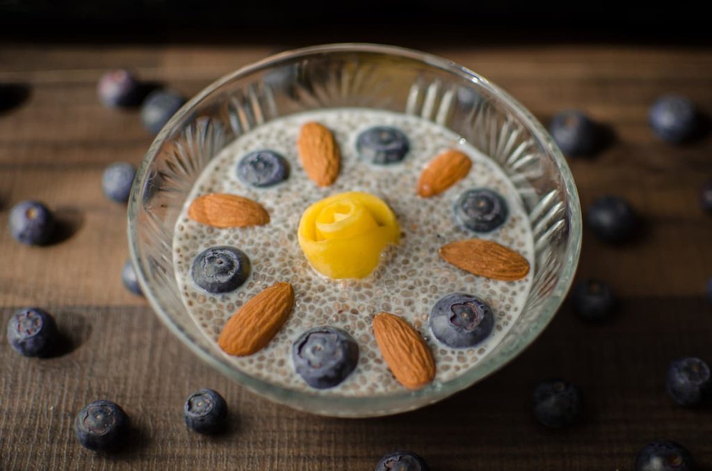 Imagem mostra iogurte natural com chia e mirtilo.